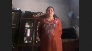 A Pakistani woman undresses, revealing her breasts and genitals