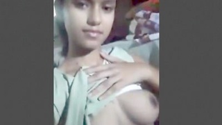 A young Indian girl displays her large breasts and intimate parts in a solo video